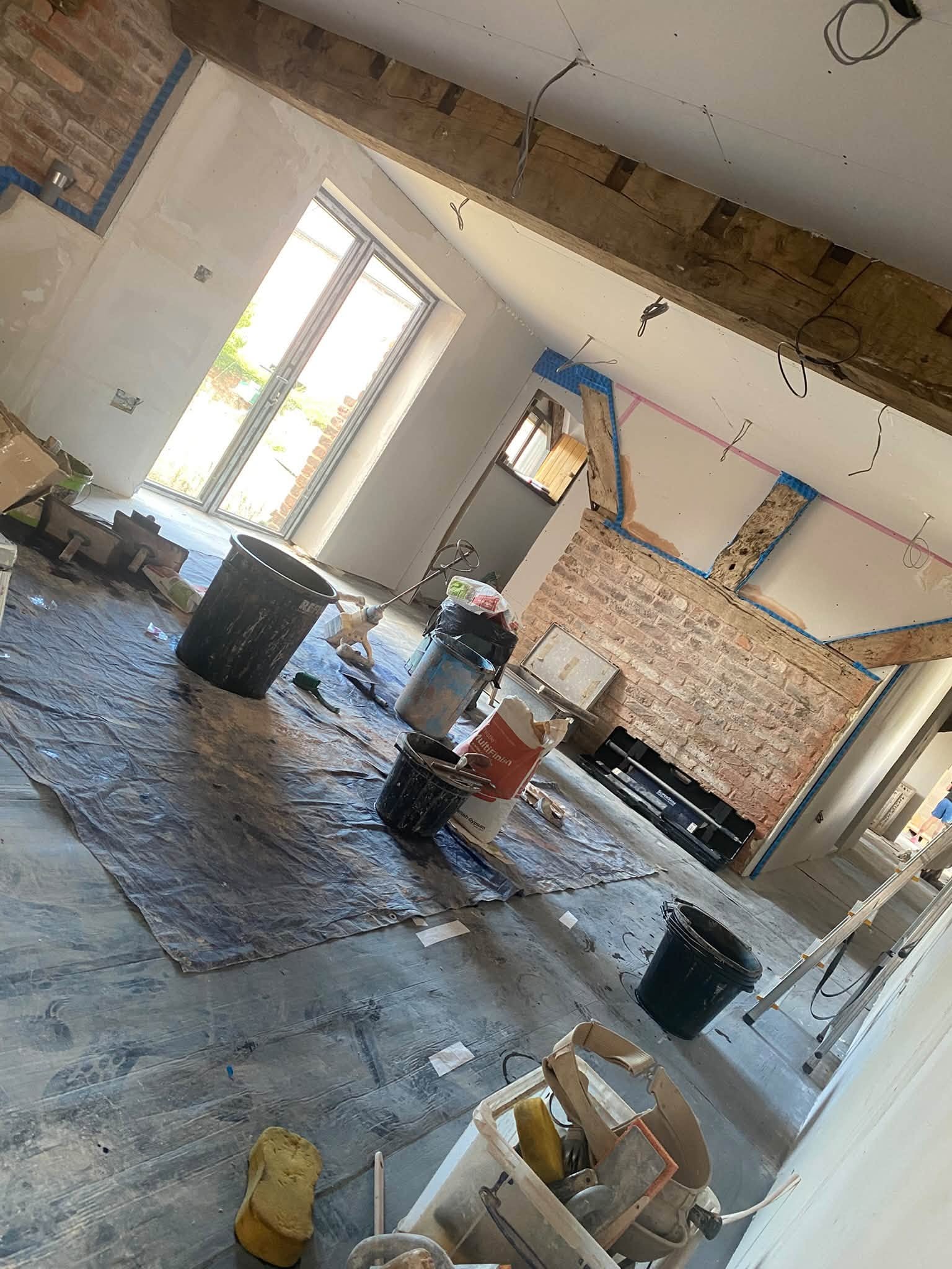 Beamed cottage room in Ellesmere mid-job, with fresh plaster up to the beams