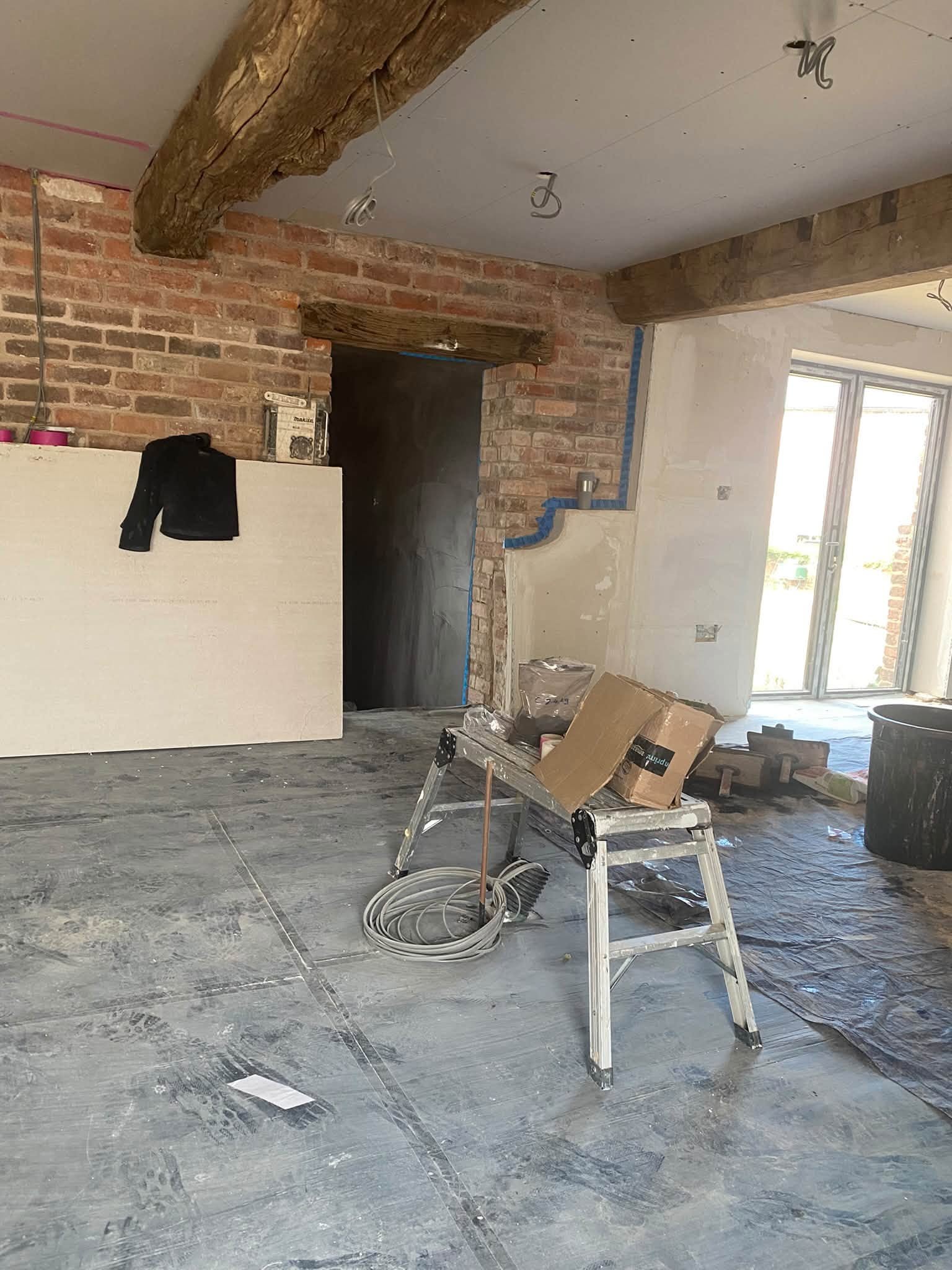 Cottage room in Ellesmere with an oak beam, brickwork and new plaster