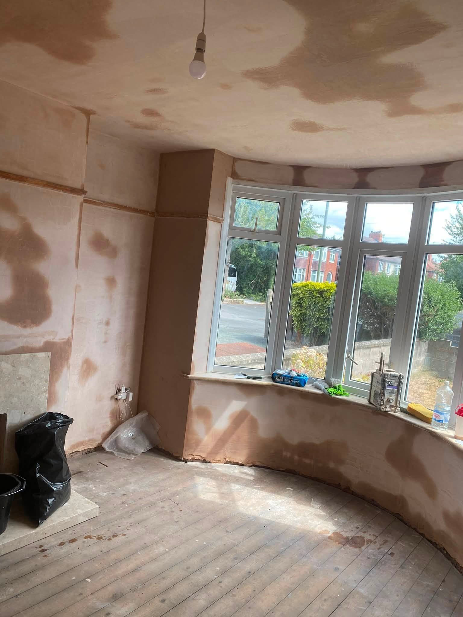 Bay window room in Oswestry with fresh plaster drying on walls and ceiling