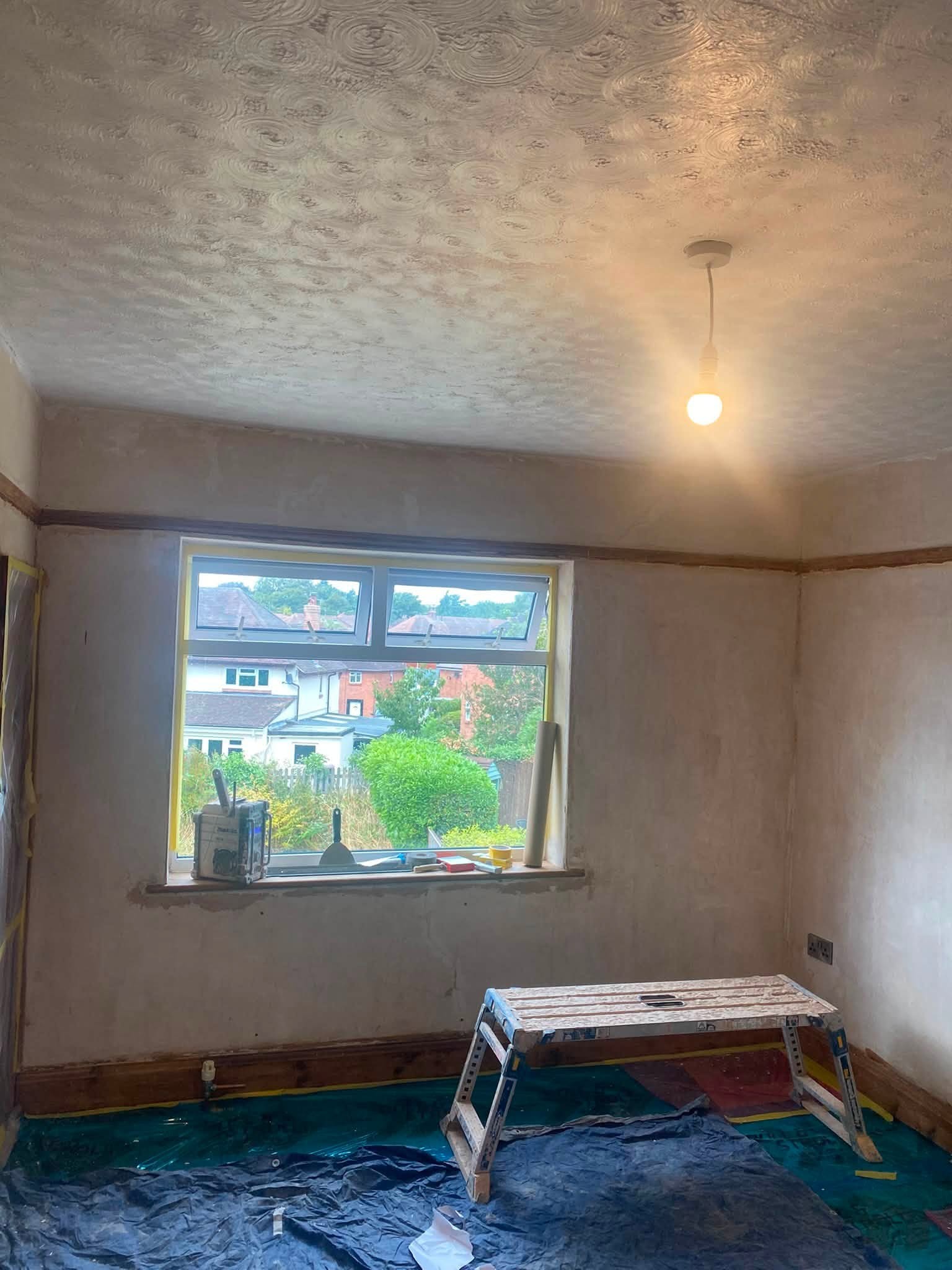 Bedroom in Oswestry with fresh plaster on the walls and ceiling and a window looking onto the street