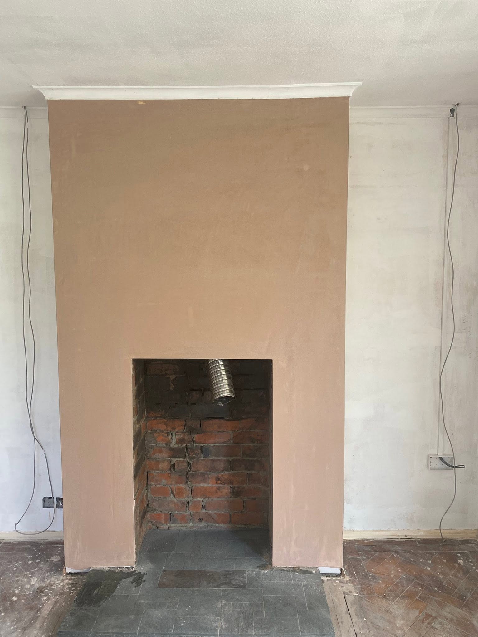 The same chimney breast in Trefonen after plastering, smooth and square round the fireplace