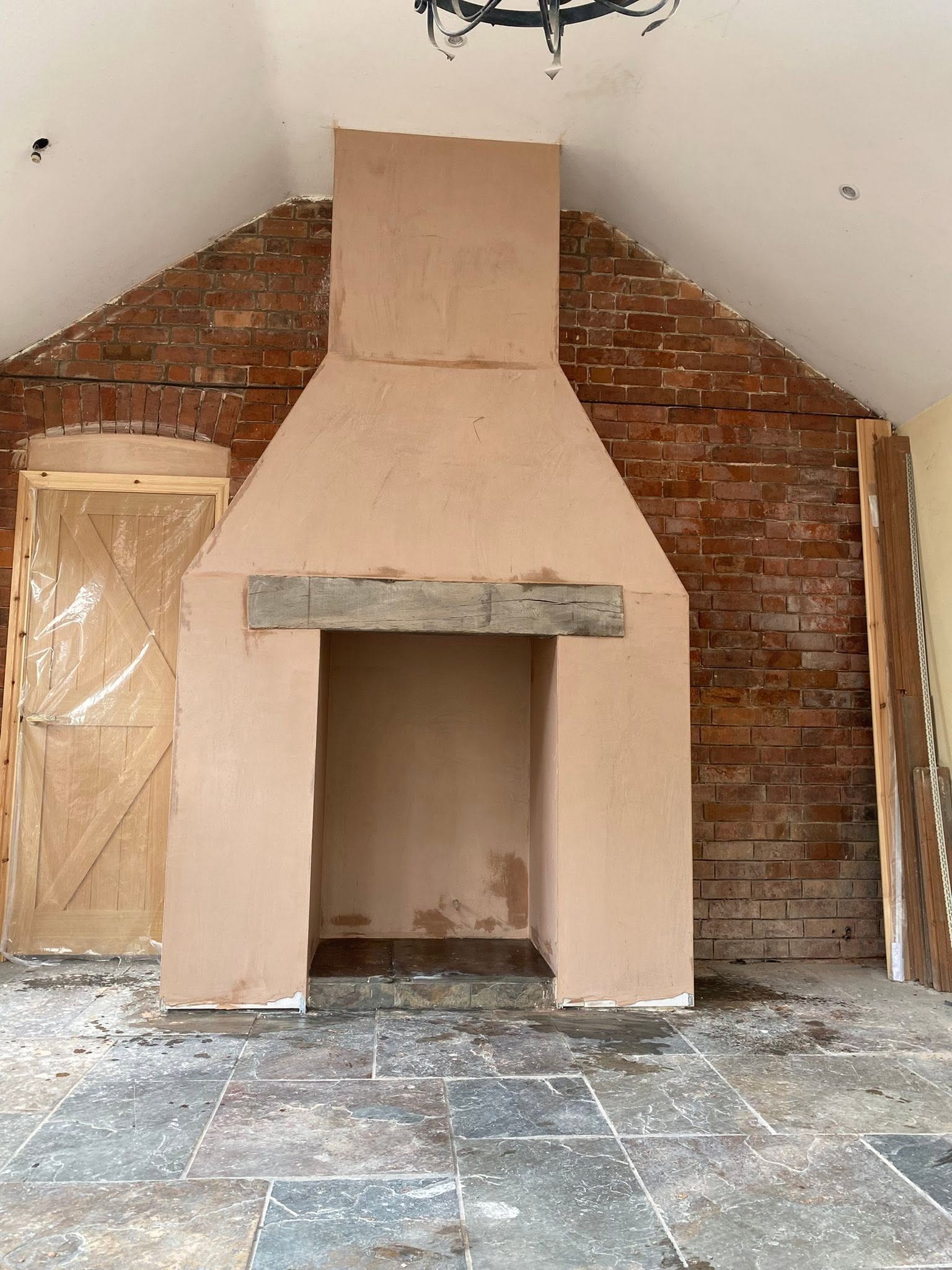 Inglenook-style fireplace in Ruyton-XI-Towns, plastered chimney with an oak beam against exposed brick