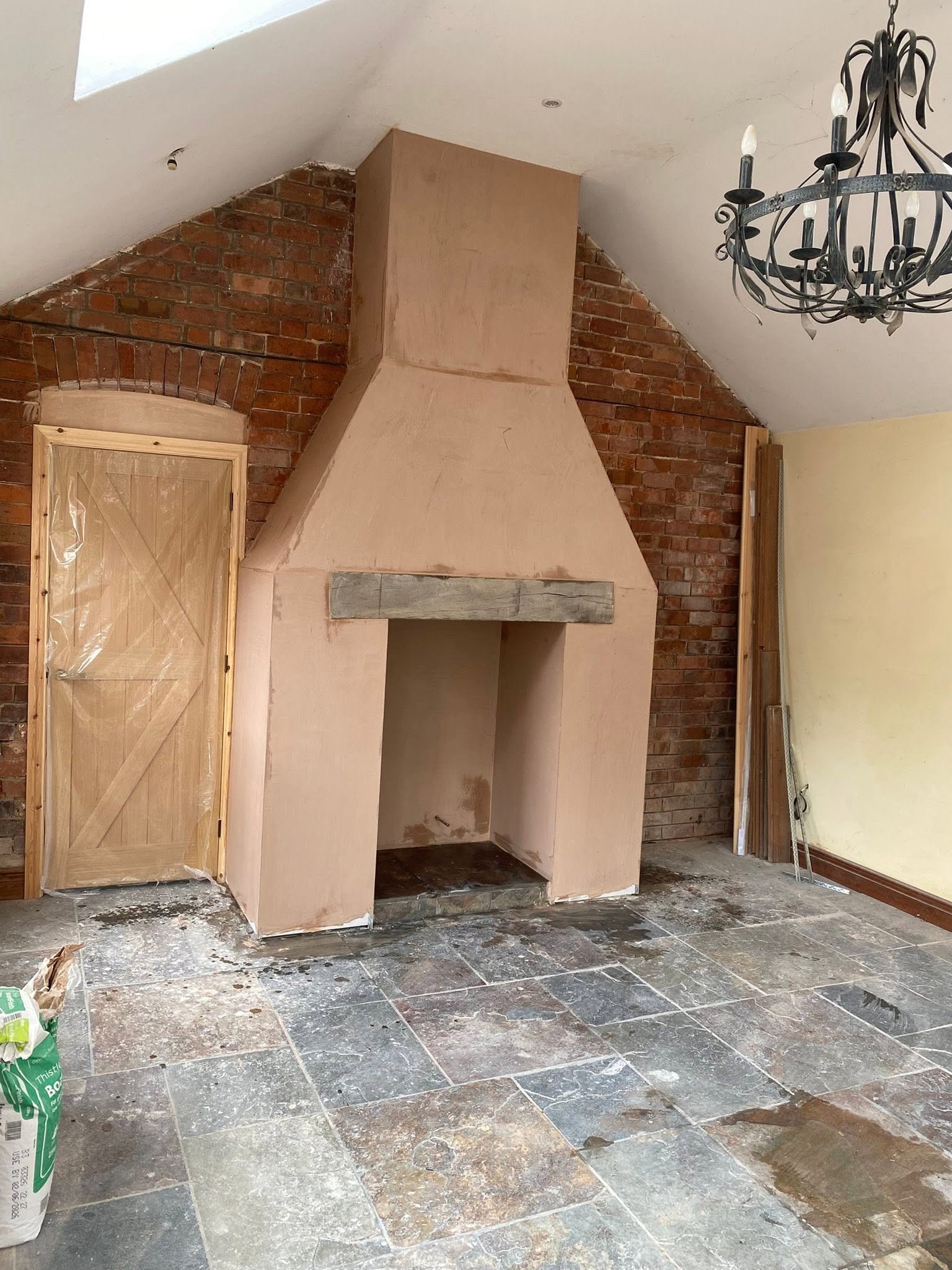 Fireplace in Ruyton-XI-Towns with a plastered chimney, oak beam and exposed brick gable