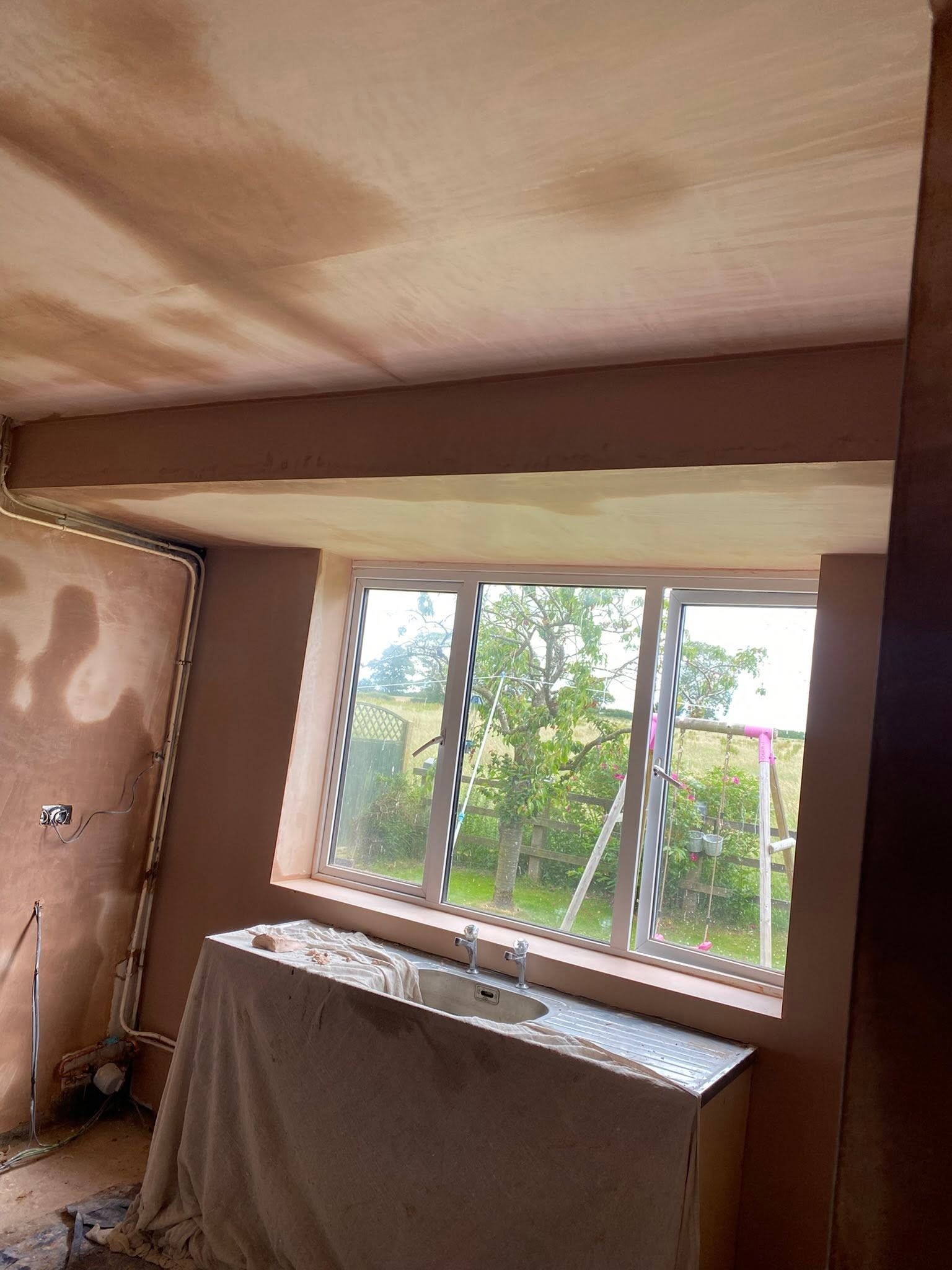 Kitchen in Saint Martins with fresh plaster on the walls and ceiling round the window