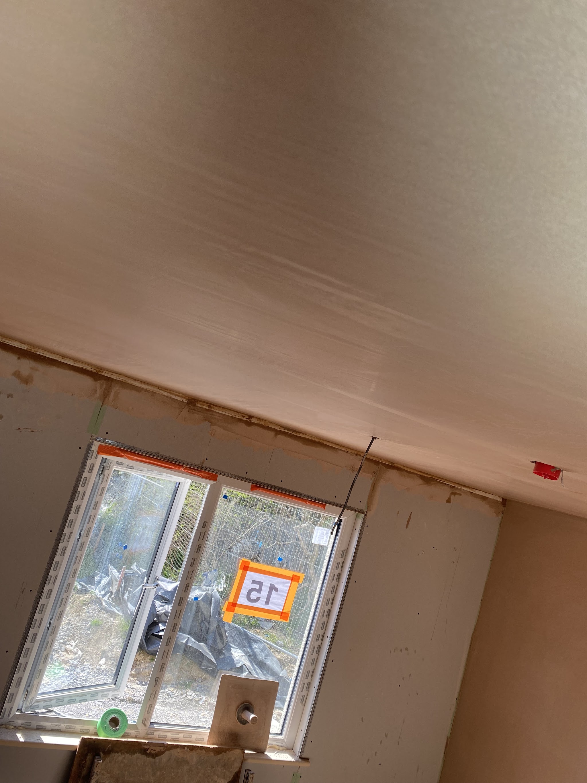 Fresh plaster on a ceiling and round a new window in a new build
