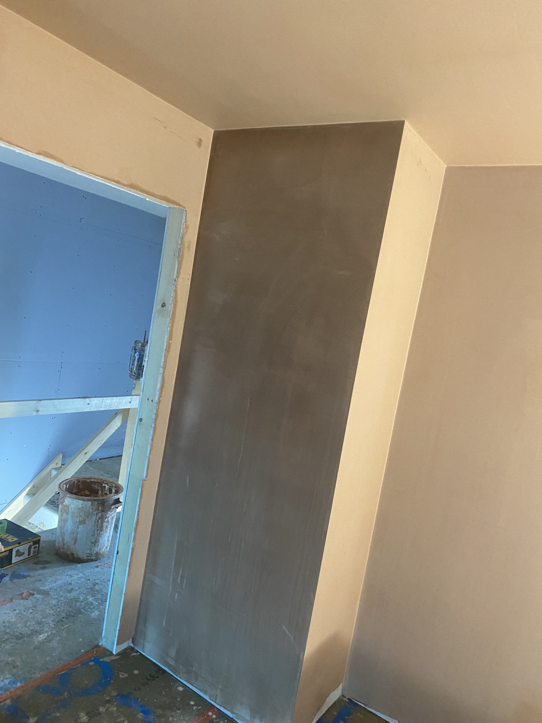 Boxed-in column plastered and drying beside a doorway