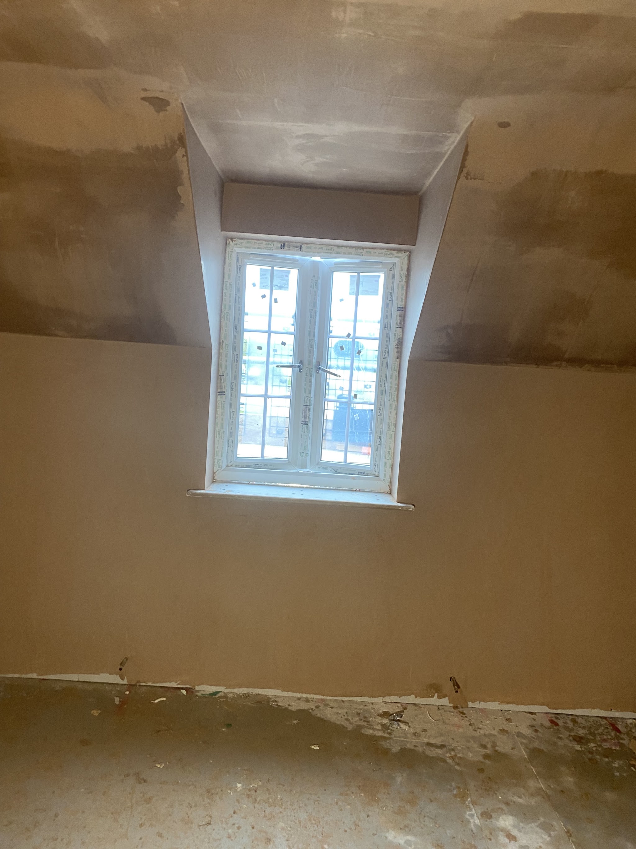 Dormer window room in a new build with fresh plaster
