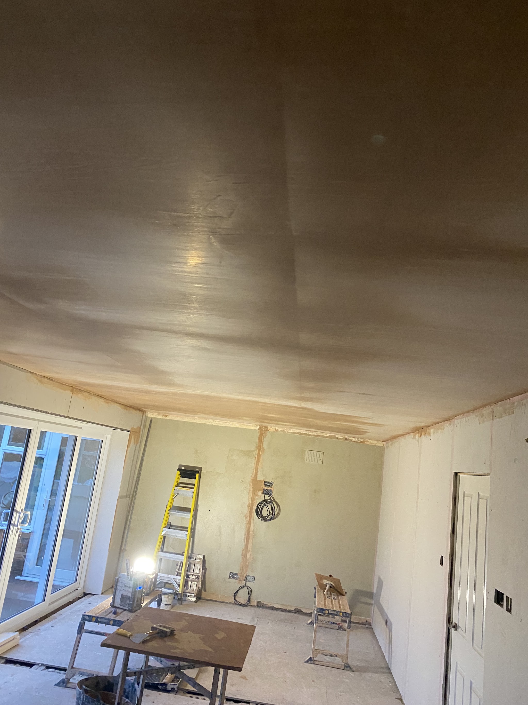 Large open-plan room in a new build with walls and ceiling freshly plastered